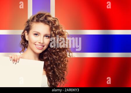 Cheerful woman showing white banner on the Norway flag background. Live, work, education and internship in Norway Stock Photo