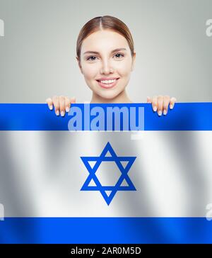 Beautiful happy young woman showing the Israel flag background. Live, education and work in Israel Stock Photo