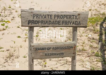 Private property sign on the beach with gullfeed (Scaevola plumieri), Ponta Malongane, Mozambique. Stock Photo