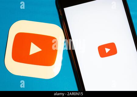 Los Angeles, California, USA - 22 January 2020: YouTube app logo and phone with icon close up on blue background, Illustrative Editorial Stock Photo
