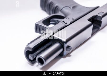 A black 9mm semi automatic pistol with an opened slide on a white background Stock Photo