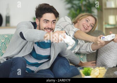 young couple playing video games at home Stock Photo