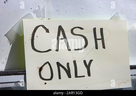 old weathered cash only sign in the window of a rural store Stock Photo