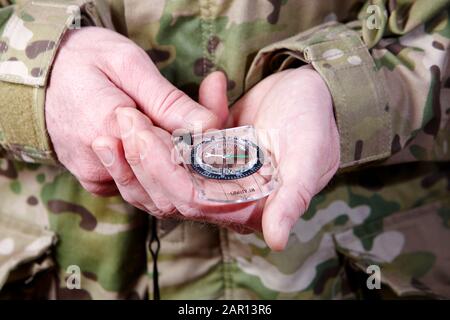 man in combat fatigues holding compass Stock Photo