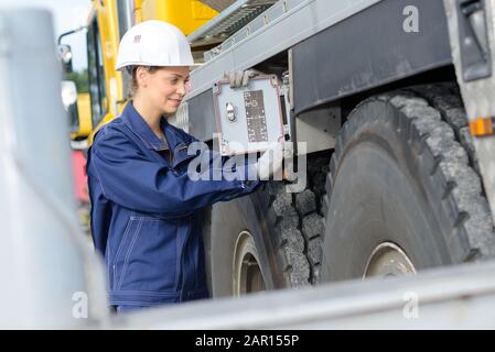 woman operating controls on an industrial vehicle Stock Photo