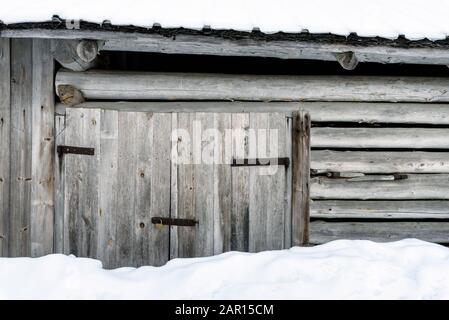 Old wooden barn door with snow Stock Photo