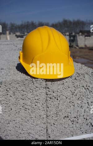yellow hard hat sitting on concrete blocks on a building site in the uk Stock Photo