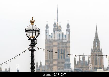 Dolphin lamp standard on Thames Embankment in London at the Westminster Bridge, bloored Westminster Abbey on background - image Stock Photo
