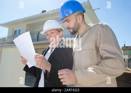 workers looking at drawings at the construction site outdoors Stock Photo