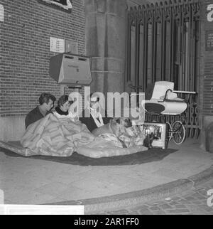 Two families (H. Pront and H. Burgering) overnight in front of the Amsterdam City Hall after they were put on the street by the death of the main inhabitant and refused the house offered by the municipality.  Family members with dog sitting on mattresses and surrounded by household items Date: 12 October 1965 Location: Amsterdam, Noord-Holland Keywords: town halls, families, housing shortage Personal name: Burgering, H., Pront, H. Stock Photo