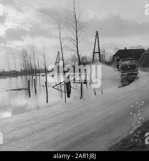 Waternuisance in the Gelderse Valley; car driving along a flooded meadow Date: 11 December 1965 Location: Gelderland Keywords: cars, floods, flooding Stock Photo