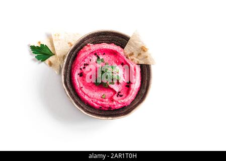Red Beetroot Hummus bowl, healthy vegan dip. Traditional Middle eastern beet hummus,  spread  with pita bread and vegetables isolated on white. Top vi Stock Photo