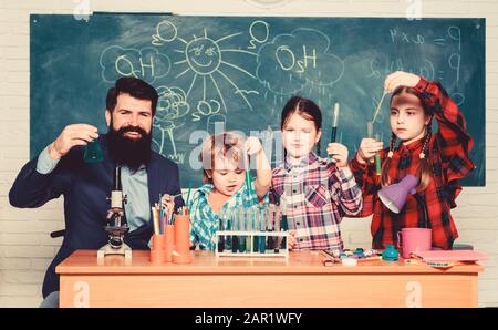 Scientists at work. students doing science experiments with microscope in lab. back to school. kids scientist studying science. happy children. Little kids learning chemistry in school laboratory. Stock Photo