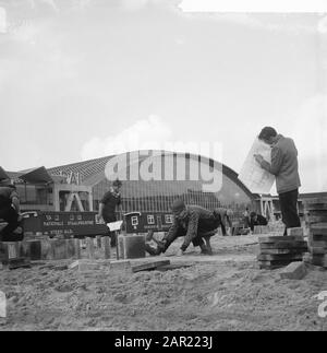 Student street makers lay parking strips for the new RAI Annotation: On the construction chain it says: National Steel Industry De Steeg Gld and Ruberoid Maassluis Date: 28 November 1960 Location: Amsterdam Keywords: STRATENMAKERS, pupils, parking Institution name: RAI Stock Photo