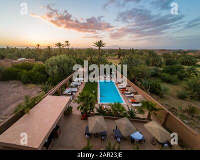 OUARZAZATE, MOROCCO - Jun 07, 2018: Beautiful view of a swimming pool in hotel Riad Dar Chamaa at sunset Stock Photo