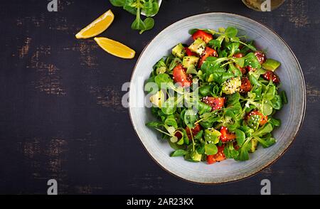 Fresh salad tomato, avocado, corn salad and chia seed. Healthy food concept. Vegetarian / vegan cuisine. Dietary food. Top view, overhead Stock Photo