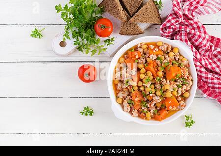 Chili con carne of turkey  with chickpeasand pumpkin on white wooden table.  Chili with meat. Mexican / Texas traditional food. Top view, overhead Stock Photo