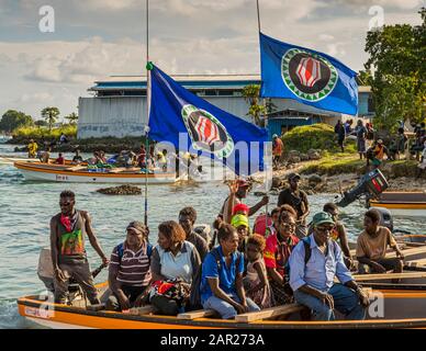 Locals from Bougainville in a small ferry boat with the independence flag from Papua New Guinea hoisted