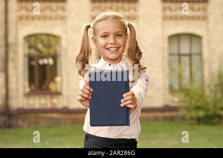 Knowledge day. Ready for lessons. Secondary school student. Cute smiling small child hold book. Adorable little girl school student. Study language. School education concept. Cute little bookworm. Stock Photo