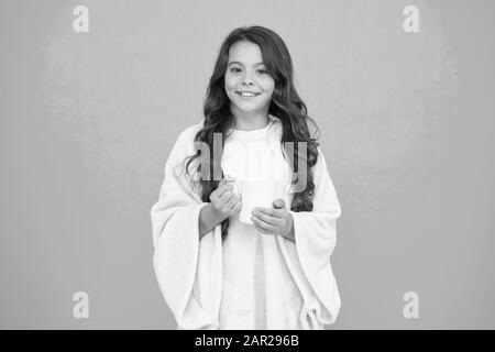 Health Benefits of Drinking Milk Before Bed. Little child hold mug. Girl in pajamas drinking tea. Relaxation before sleep. Drinking milk just before heading to bed. Bedtime Beverages. Evening routine. Stock Photo