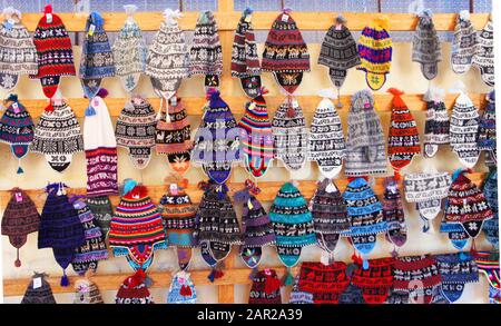 Colorful traditonal hand knitted Peruvian hats line the wall of a market on Taquile Island, Lake Titicaca, Peru Stock Photo