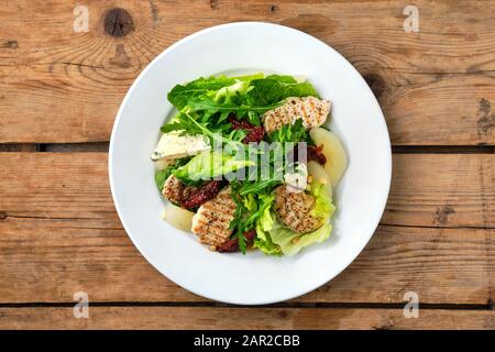 Overhead view of salad with roasted turkey, dried tomato, gorgonzola, canned pear and pine nuts Stock Photo