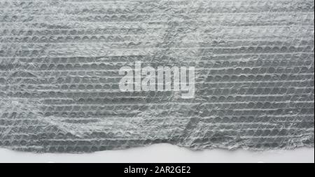 fragment of a transparent film with air for the transportation of parcels is glued on gray polyethylene, inside of the envelope Stock Photo