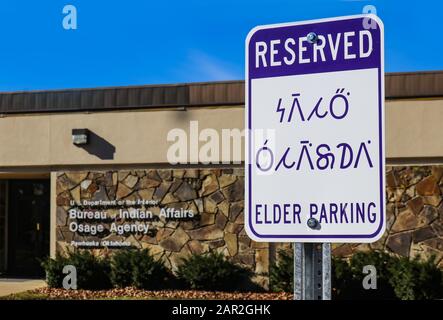 Reserved - Elder Parking sign in English and the Osage Indian Language (Wazhazhe) outside the Bureau of Indian Affairs Osage Agency in Pawhuska Ok USA Stock Photo