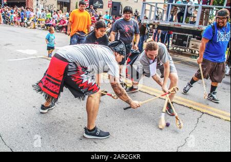 3-31-2018 Tahlequah USA - Native American young men playing exhibition game of traditional stickball in the middle of the street during parade - funny Stock Photo