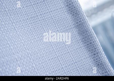 The fabric of a white curtain is seen close-up against a window. Stock Photo