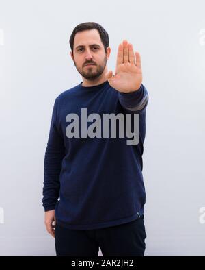 Young handsome man against white wall Stock Photo