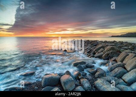 Sunset over Clavell Pier, the remains of an old stone jetty at Kimmeridge Bay on the Dorset Coast Stock Photo