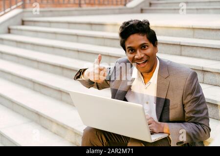 Young handsome Indian man is sitting on the steps Stock Photo
