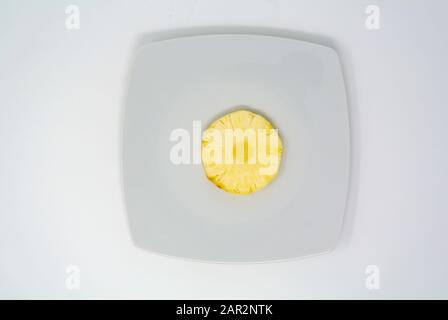 a slice of pineapple on a white dish Stock Photo