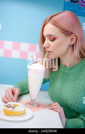 Portrait of a pretty girl in cafe. Pretty blonde girl with a milkshake Stock Photo
