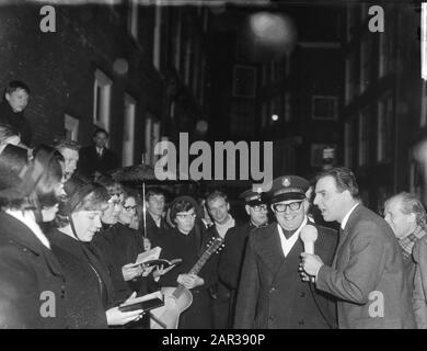 Willem Duys for his program For the fist away on Amsterdamse Zeedijk, here in conversation with musicians from Leger des Salvation Date: 23 December 1965 Location: Amsterdam, Noord-Holland Keywords: conversations Personal name: Duys, Willem Institution name: Leger des Salvation, Front de Fist Road Stock Photo