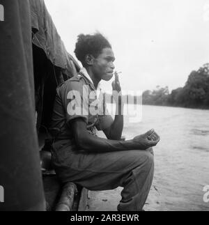 [Patrol boat on a river. Dutch military smokes a cigarette] Date: 1947/01/01 Location: Indonesia, Dutch East Indies Stock Photo