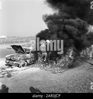 Rescue demonstration at Zandvoort circuit, volunteers with equipped BMW extinguishing burning wreck Date: 9 april 1974 Location: Noord-Holland, Zandvoort Keywords: VOLUNTERS, demonstrations Stock Photo