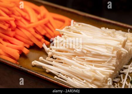 Julienne carrots and Enokitake Mushrooms cut up and used for making Sushi Stock Photo