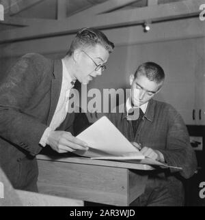 The work of the Stichting War Foster Children in the field of care of children of N.S.B.-ers  Boy in school bench with a teacher Date: October 1945 Keywords: education, Second World War Stock Photo