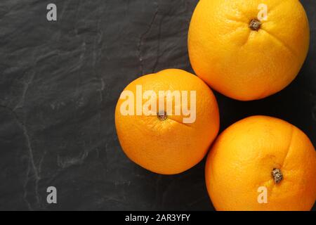 High angle shot of three oranges isolated on a black background Stock Photo