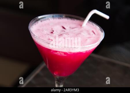 High angle closeup shot of a glass filled with a pink drink with a white straw Stock Photo