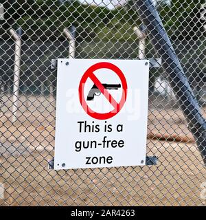 Closeup shot of a gun-free zone sign on a fence Stock Photo