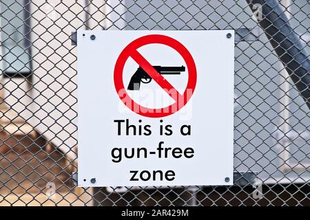 Closeup shot of a gun-free zone sign on a fence Stock Photo