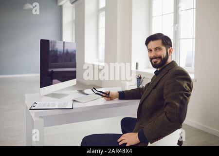 Businessman works at the computer at the table in the workplace in the office Stock Photo