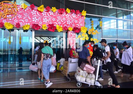 People, many wearing masks to reduce the risk of infection, enter Cam Ranh International Airport which is decorated for the Tet New Year holiday. The airport is located on Cam Ranh Bay in Cam Ranh, a town in Khánh Hòa Province in Vietnam. It serves the city of Nha Trang, which is 30 km from the airport. The airport code is CXR. Stock Photo