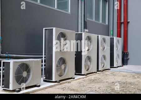 Condensing unit of air conditioning systems. Condensing unit installed in a row outside the building. Stock Photo