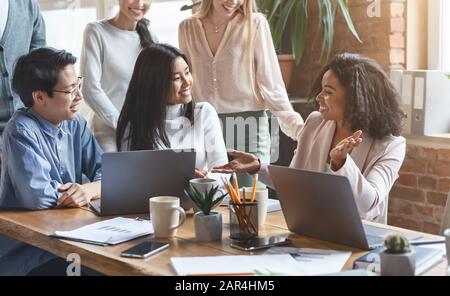 Professional afro woman sharing business ideas with colleagues Stock Photo