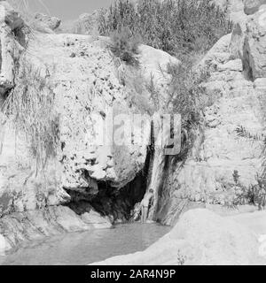 Israel 1964-1965: Ein Gedi  Ein Gidi. Rock face with the Sudarbron and a bath guest. Date: 1964 Location: Dead Sea, Ein Gedi, Israel Keywords: bathers, rocks, waterfalls Stock Photo