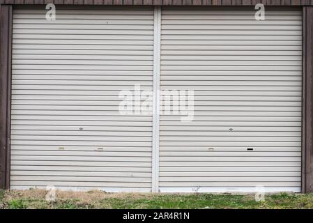 An old metal roller shutter at a closed store front. Stock Photo